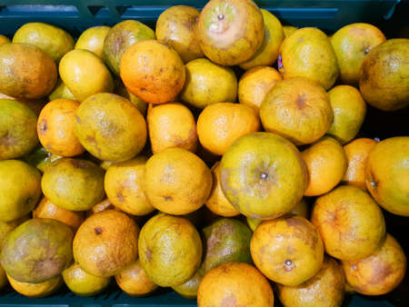 Top view of orange fruit as a background on market stand in Thailand. Fresh mandarin oranges group.の写真素材