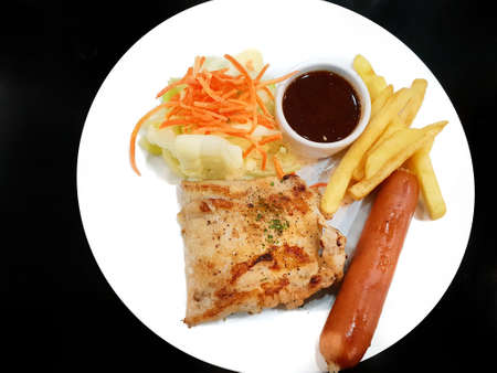 Top view of grilled chicken steak with french fries, sausage and salad vegetable isolated on white background. Copy spaceの写真素材