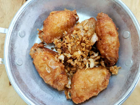 Top view of fried chicken wings with fried garlic on plateの写真素材