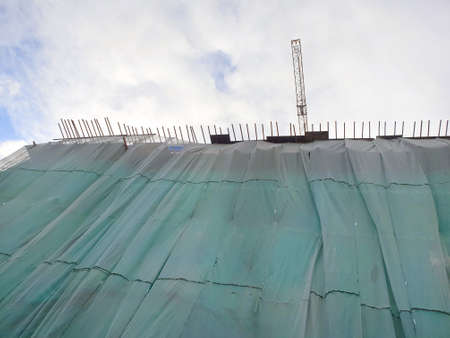 Safety net green of construction site on sky background, looking up of architectural building...