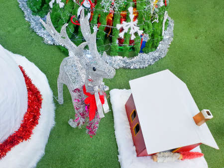 Decorated Christmas with reindeer, tree, home on green grass background, Holiday background, Happy...