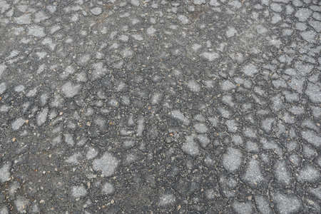 Asphalt road with cracks as a background, old road texture
