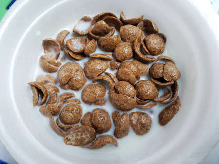 Top view of cereal chocolate flavor and milk on white bowl, Concept for a healthy diet