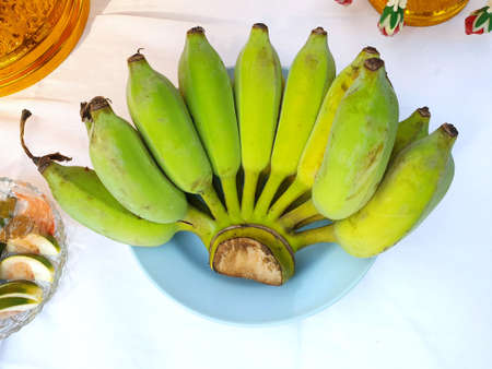 Bunch of banana on blue plate to worship on the table, Top view, Pisang Awak bananaの写真素材