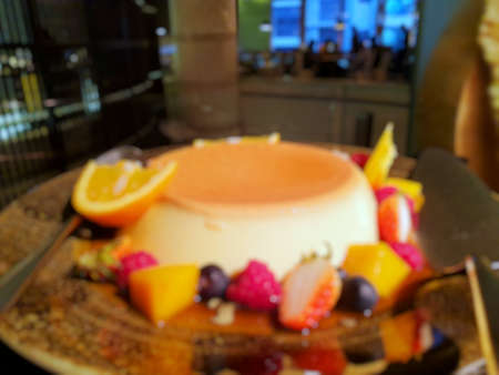 Blurred of pudding with raspberries, orange, kiwi, mango, strawberry and apple in restaurant as a...