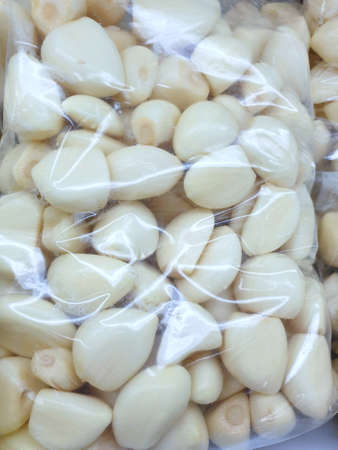 Fresh garlics in package as a background in the supermarket for sale, Top view (Allium sativum), resdy to cooking, verticalの写真素材
