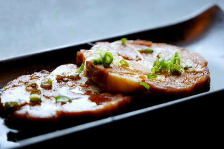 Japanese food style, Selective focus of sliced braised pork on black plate in restaurant (chashu),...