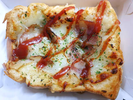 Top view of Pizza toasted bread with bacon and ketchup isolated on white background, space for your text, ready to eat or serveの写真素材