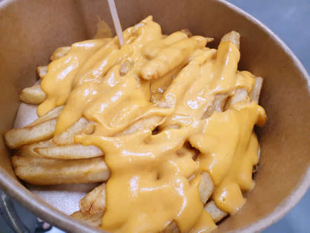 Top view of french fries with cheese ready to eat or serve, fast food restaurant, the popular street...