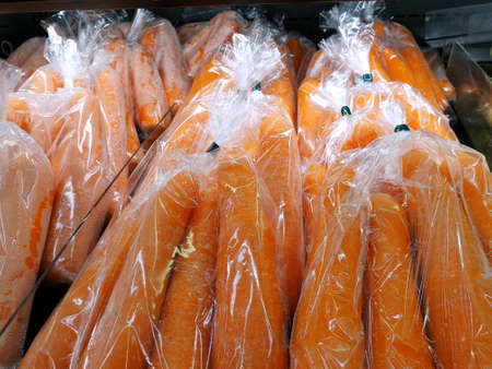 Fresh garden carrots in plastic bag for sales as a background, in supermarket, for making drinks or salads, healthy food conceptの写真素材