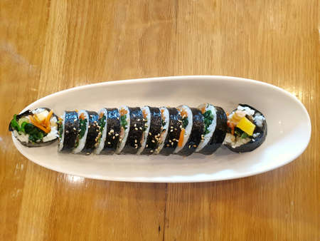 Korean food style, Top view of gimbap or kimbap in white plate on wooden table as a background, Ready to eat or serve, Space for your textの写真素材