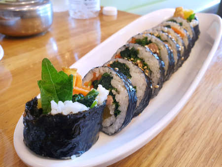 Korean food style, Selective focus of gimbap or kimbap in white plate on wooden table as a background, Ready to eat or serve, Space for your textの写真素材