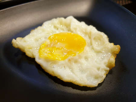 Top view of fried egg on dark background, Sunny side Up, Ready to eat or serveの写真素材
