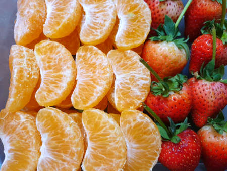 Top view of orange and strawberry fruit as a background for sale on market stand in Thailand, Fresh fruit ready to eat or making drinks and salads, Healthy conceptの写真素材
