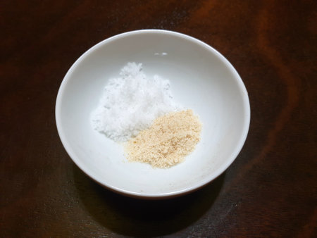Top view of salt and Chicken powder or Aromat in a white bowl on wooden table as a background, copy space, ready to cookingの写真素材