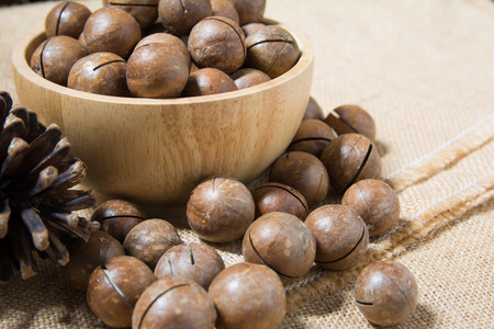 Close up of macadamia in wooden bowl and on sackclothes.の写真素材