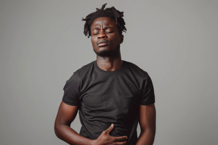 A man with long dreadlocks stands confidently in front of a gray backdrop.の素材