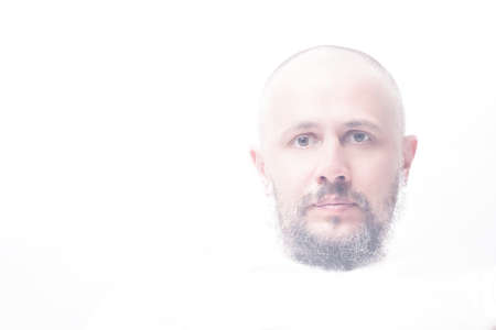 High-key portrait of bald man with grey beard calm looking straightの写真素材