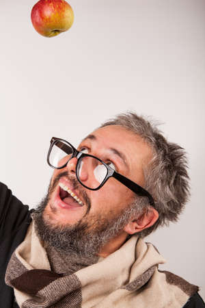 Old man with beard and big nerd glasses happy looking up on the appleの写真素材