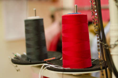 Red reel in atelier, closeup photo. Sewing tools, accessories. selective focus.