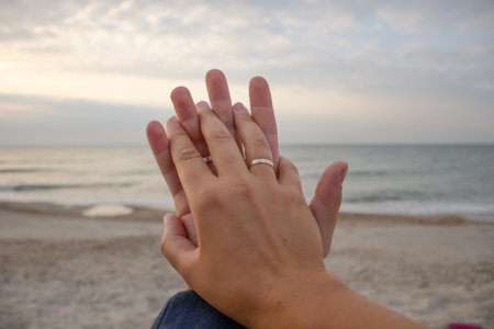 Couple in love holding hands by sea on their honeymoon