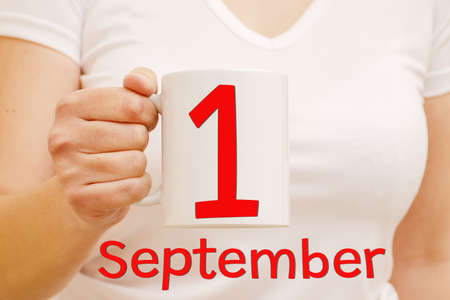 Celebration and business concept. White mug with red inscription September 1 in female hand.の写真素材
