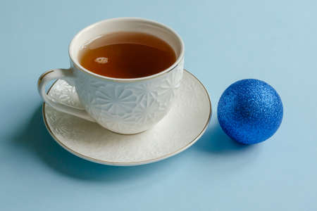 White cup tea on blue background, christmas ball, home comfort conceptの写真素材