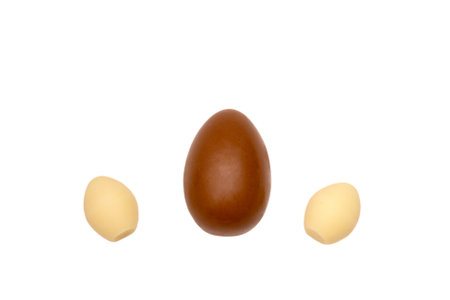 Half chocolate egg isolated on a white background, top view. Dark chocolate half between milk chocolate eggs, flat layの写真素材