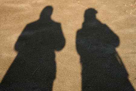 Shadows of people on ground. Couple in love walking in nature on sunny dayの写真素材