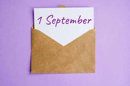 Kraft envelope with white sheet of paper and the inscription September 1 on a lilac background. Correspondence calendar and memorable date conceptの写真素材