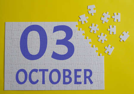 3 october calendar date on a white puzzle with separate details. Puzzle on yellow background with blue inscriptionの写真素材
