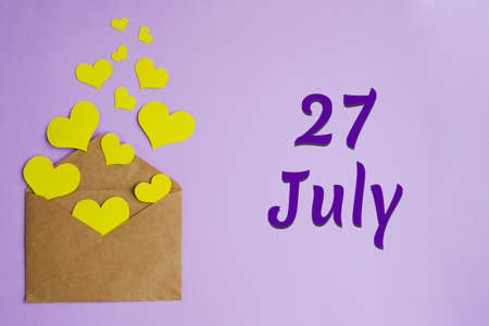 Brown envelope with yellow hearts on lilac background and inscription July 27, holiday concept.