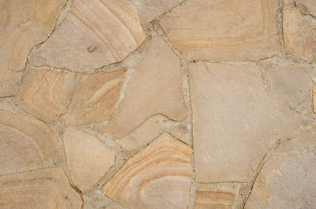 The texture of sandstone flagstone, road paved with it. Beige seamless pattern