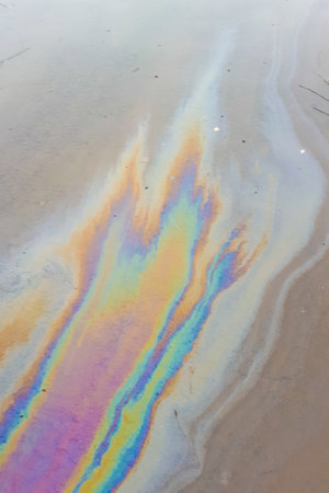 Gasoline stains on the pavement. Scheme of an oil spill on a street in a puddle.の写真素材