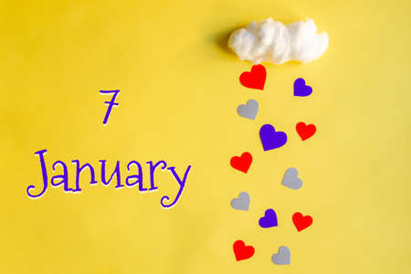 7 january day of month, colorful hearts rain from white cotton cloud on yellow background. Valentine's day, love and wedding conceptの写真素材