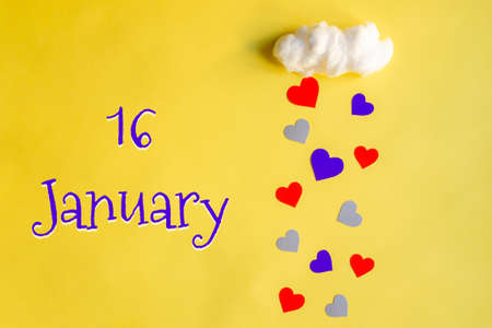 16 january day of month, colorful hearts rain from white cotton cloud on yellow background. Valentine's day, love and wedding conceptの写真素材