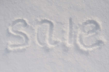 Inscription SALE on white snow. horizontal photo. Flat lay with business conceptの写真素材