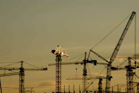 Crane and construction site at sunset. Building development and construction conceptの写真素材