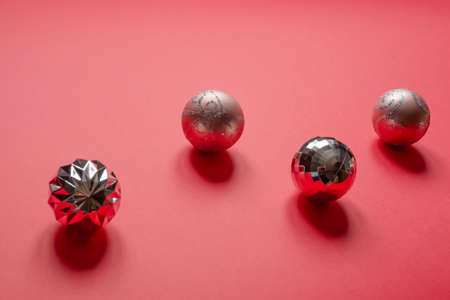 Silver and pink Christmas balls on red background. Horizontal photo close-up