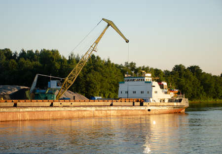 Floating crane in the river port on summer day. The concept of export and import of goodsの写真素材
