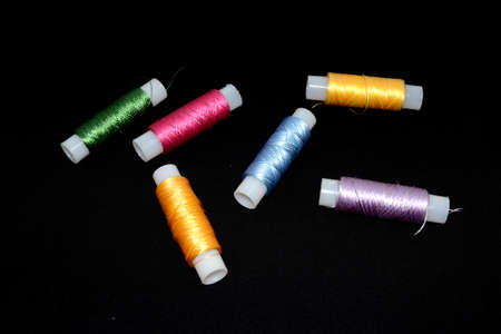 Skins of silk thread for embroidery. Skins are yellow, green, pink, purple and blue. Black...
