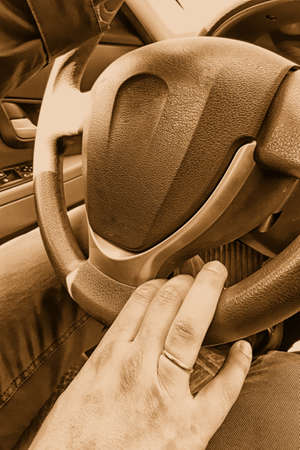 Male hand on a steering wheel in a car. Vertical photo, tinted. travel conceptの写真素材