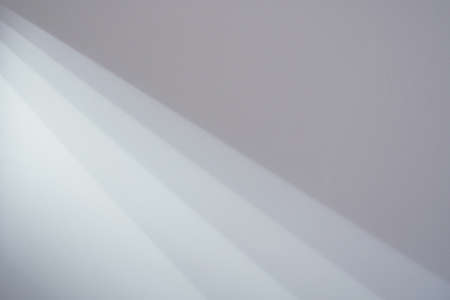 Beautiful luminous background. Rays of light from a lamp on the ceiling on the wall of the room. Light and dark sharp contrasting transitions.の写真素材