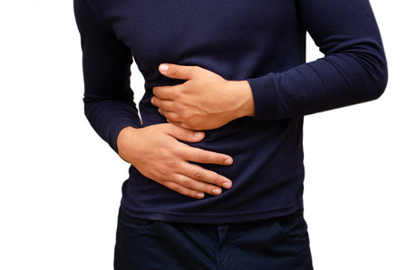 The man has a stomach ache, he holds on to it. Photo horizontal isolatedの写真素材