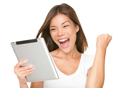 Tablet computer woman excited looking at touch pad pc. Cheerful happy fresh Asian Caucasian female model.の写真素材