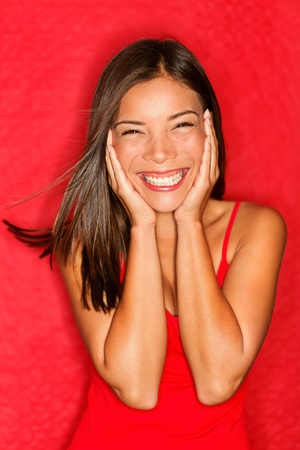 Happy young asian woman excited smiling cheerful holding head in joy. の写真素材