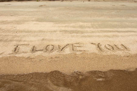 waves moving in to erase it,I love you.の写真素材