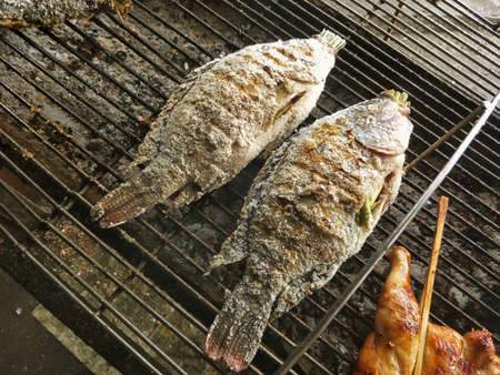 grilled fish on a charcoal grill in the market place.