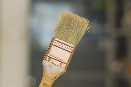 Paint brush with the wooden handle.