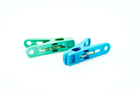 Blue and Green plastic clothespin on white background, A line of color clothespins close-up on a white background.の写真素材